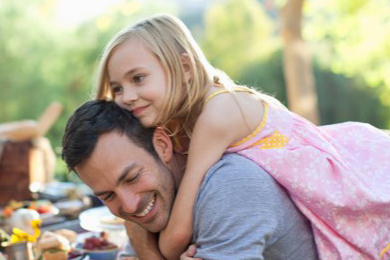 young girl with hear arms wrapped around her Dad