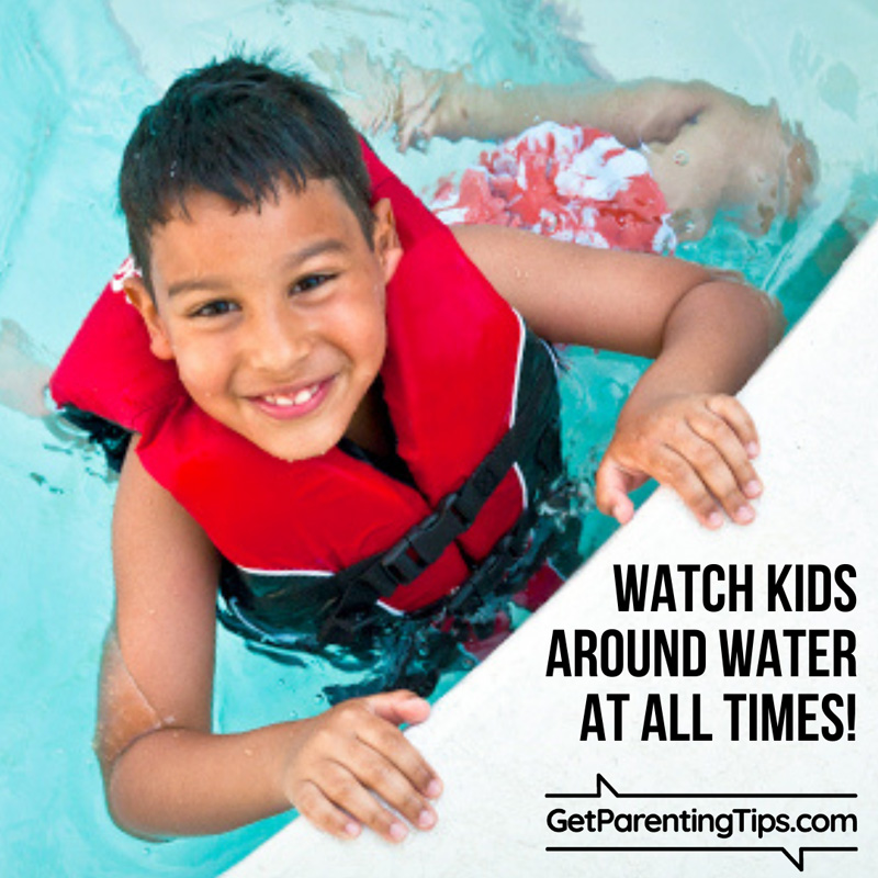 smiling child wearing a life jacket in swimming pool. Text: Watch Kids around water at all times! GetParentingTips.com