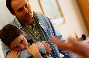 Hombre envolviendo su brazo alrededor de un niño